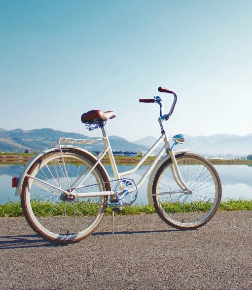 A white bicycle parked on the side of a road.