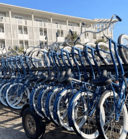 A bunch of bikes are parked in front of the hotel.
